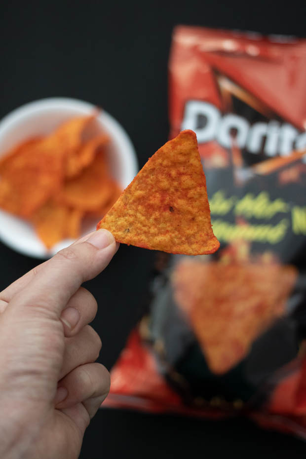 The Doritos chip has a darker red colour from the Flamin' Hot seasonin...